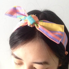 Load image into Gallery viewer, An example of a headband tied on a head in a bow.
