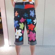 Load image into Gallery viewer, black denim 3/4 length jeans with multicoloured 60s style flowers. worn with a white shirt with colourful swatch squares
