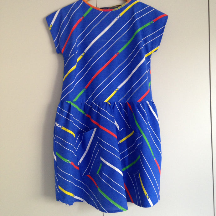 Front view of blue dress with pockets. The fabric has diagonal stripes in white, yellow, green and red.