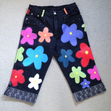 Load image into Gallery viewer, black denim 3/4 length jeans with multicoloured 60s style flowers. hem cuffs have embroider black flowers
