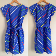 Load image into Gallery viewer, Front and back view of blue dress with tie belt. Fabric has white, red and green stripes.
