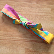 Load image into Gallery viewer, Candy coloured stripe headband tied in a bow. Has big horizontal stripes.

