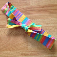 Load image into Gallery viewer, Candy coloured stripe headband tied in a bow. The bow has horizontal stripes. The back and side have vertical stripes.
