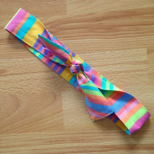 Load image into Gallery viewer, Candy coloured stripe headband tied in a bow. Parts of the bow has diagonal stripes and another with horizontal stripes.
