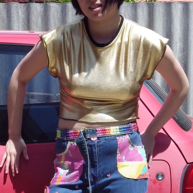metallic gold crop t shirt with black neck rib. worn with colourful jeans and belt