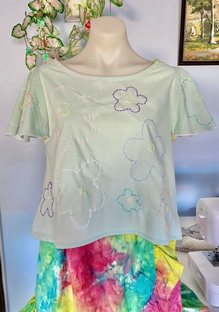 pale mint short sleeve top with 60s style stitched flowers in pastel colours and deep purple